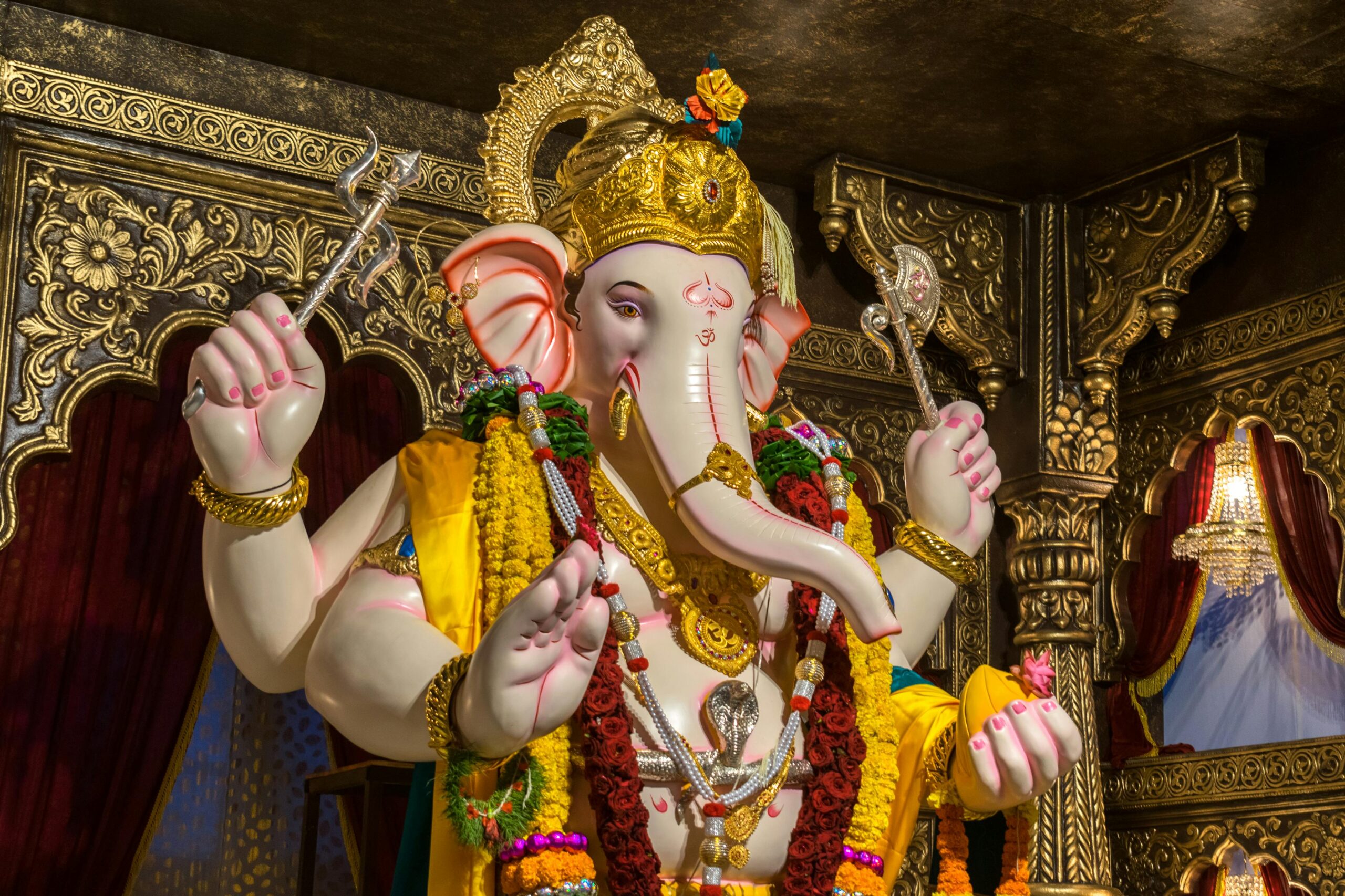 Intricate statue of Lord Ganesha adorned with vibrant garments and jewelry, capturing cultural richness.